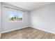 Empty room with light walls, hardwood floors, and a large window overlooking a quiet neighborhood at 4860 S Field Way, Littleton, CO 80123