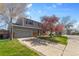 Two story home with an attached two car garage, grass yard, and blue sky at 4860 S Field Way, Littleton, CO 80123