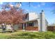 A two story home with grey siding and a brick foundation sits on a green lawn under a blue sky at 4860 S Field Way, Littleton, CO 80123