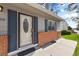 A front door with an oval glass design, dark blue shutters, and brick accents enhance the exterior at 4860 S Field Way, Littleton, CO 80123