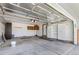 Spacious garage features ample storage with white cabinets, wood shelving, and easy access to the home's interior at 4860 S Field Way, Littleton, CO 80123