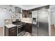 Updated kitchen features a stainless-steel range hood and stainless-steel refrigerator at 4860 S Field Way, Littleton, CO 80123
