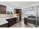 Renovated kitchen featuring stone backsplash, dark wood cabinets, and stainless appliances at 4860 S Field Way, Littleton, CO 80123