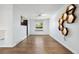 Bright living room with light wood floors, honeycomb wall design, and views to the kitchen at 4860 S Field Way, Littleton, CO 80123