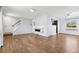 Open-concept living room with light wood floors, staircase, fireplace, and views to the kitchen at 4860 S Field Way, Littleton, CO 80123