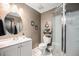 Functional bathroom featuring a walk-in shower, round mirror, and neutral earth-tone decor at 6021 Lynx Creek Cir, Erie, CO 80516