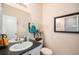 Powder room with a sink, mirror, and toilet, featuring neutral colors and simple decor at 6021 Lynx Creek Cir, Erie, CO 80516