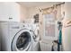 Efficient laundry room with modern washer and dryer, storage cabinets, and a bright window at 6021 Lynx Creek Cir, Erie, CO 80516
