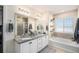 Well-lit main bathroom featuring a dual vanity, soaking tub, and a separate shower at 6021 Lynx Creek Cir, Erie, CO 80516