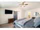 Stylish main bedroom features a ceiling fan, TV and barn door access to the main bathroom at 6021 Lynx Creek Cir, Erie, CO 80516