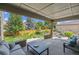 Wide view of fenced backyard from a covered patio seating area with table, chairs, and outdoor sofa at 3890 Tabor Ct, Wheat Ridge, CO 80033