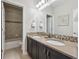 Elegant bathroom showcasing a double vanity and a view of a tiled shower at 3890 Tabor Ct, Wheat Ridge, CO 80033