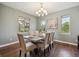 Dining room boasts wood floors, a chandelier, and a large window letting in plenty of natural light at 3890 Tabor Ct, Wheat Ridge, CO 80033