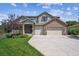 Charming two-story home with brick accents, a well-manicured lawn, and a two-car garage at 3890 Tabor Ct, Wheat Ridge, CO 80033