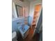 A bathroom with a light blue sink, blue tiling, and open shelving at 444 S Jersey St, Denver, CO 80224
