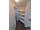 A bathroom with shelving and a glimpse of a blue tiled sink and mirror at 444 S Jersey St, Denver, CO 80224
