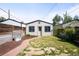 This backyard features a pathway, an old water trough, grass, and is surrounded by fences and other houses at 3375 W 37Th Ave, Denver, CO 80211