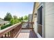 This balcony has wood flooring and wood railing with a view of the houses in the neighborhood and tree tops under a blue sky at 3375 W 37Th Ave, Denver, CO 80211