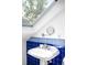This bathroom features a skylight, a round tilting mirror, and blue and white tiled trim at 3375 W 37Th Ave, Denver, CO 80211