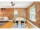 Dining room boasts exposed brick, hardwood floors, and modern chairs, perfect for entertaining at 3375 W 37Th Ave, Denver, CO 80211
