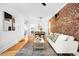 Open-concept living space with exposed brick wall, hardwood floors, and modern decor at 3375 W 37Th Ave, Denver, CO 80211