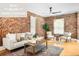 Inviting living room featuring exposed brick walls, hardwood floors, and comfortable seating at 3375 W 37Th Ave, Denver, CO 80211