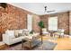 Inviting living room featuring exposed brick walls, hardwood floors, and comfortable seating at 3375 W 37Th Ave, Denver, CO 80211