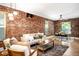 Open floor plan featuring living and dining areas with exposed brick and hardwood floors at 3375 W 37Th Ave, Denver, CO 80211