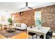 Combined living and dining space features exposed brick, hardwood flooring, and a modern ceiling fan at 3375 W 37Th Ave, Denver, CO 80211
