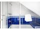 This shower features a glass door, chrome fixtures, and blue and white tiled walls at 3375 W 37Th Ave, Denver, CO 80211
