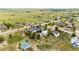 Expansive aerial view of the property showcasing the white fencing, lush greenery, neighboring houses, and open fields at 5685 Columbine Ridge Rd, Elizabeth, CO 80107