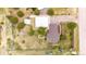 Aerial view highlighting home's brown roof, workshop, and lush greenery, with cars and a boat parked near the property at 5685 Columbine Ridge Rd, Elizabeth, CO 80107