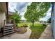 Landscaped backyard featuring a curved walkway, mature trees, and lush green lawn at 5685 Columbine Ridge Rd, Elizabeth, CO 80107