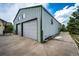 Large detached garage with gray siding and two roll up doors on a concrete slab at 5685 Columbine Ridge Rd, Elizabeth, CO 80107