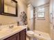 Neutral bathroom featuring a tiled shower, decorative mirror, and modern vanity at 4589 S Evanston St, Aurora, CO 80015