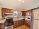 Kitchen featuring wood cabinets, stainless steel appliances, tile backsplash and view to the backyard at 4589 S Evanston St, Aurora, CO 80015