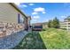 Spacious backyard with a mix of grass and rock landscaping featuring a stone and siding home exterior at 5996 Sun Mesa Cir, Castle Rock, CO 80104