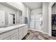 Well-lit bathroom with dual sinks, a glass-enclosed shower, and tile flooring at 5996 Sun Mesa Cir, Castle Rock, CO 80104