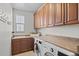 Functional laundry room equipped with a sink, ample counter space, modern washer and dryer, and overhead cabinets at 2236 S Isabell Ct, Lakewood, CO 80228
