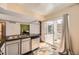 Bright kitchen featuring tile flooring, sliding glass door, and stainless steel dishwasher at 2469 S Xanadu Way # A, Aurora, CO 80014