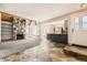 Open-concept living space with stone fireplace, kitchen access, and natural light at 2469 S Xanadu Way # A, Aurora, CO 80014