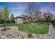 Lush backyard with mature trees and stone landscaping leading to house at 236 E Fair Ln, Centennial, CO 80121