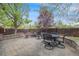 Backyard patio featuring an outdoor dining set and lush landscaping with trees at 236 E Fair Ln, Centennial, CO 80121
