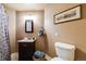 Cozy bathroom featuring a vanity with dark wood cabinets, a toilet, and neutral wall color at 236 E Fair Ln, Centennial, CO 80121