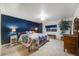 Comfortable bedroom featuring a plush bed, blue accent wall, and ample natural light from the window at 236 E Fair Ln, Centennial, CO 80121