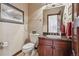 Stylish powder room features elegant wallpaper, sink with granite countertop, and decorative mirror at 30544 The Golf Club Point, Evergreen, CO 80439