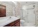 Bathroom featuring floral wallpaper, a shower, toilet, and vanity with generous counter space at 30544 The Golf Club Point, Evergreen, CO 80439