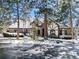 Charming home exterior featuring a stone and stucco facade, mature trees, and snowy landscaping at 30544 The Golf Club Point, Evergreen, CO 80439