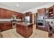 Spacious kitchen with dark wood cabinets, central island, stainless steel appliances, and tile flooring at 30544 The Golf Club Point, Evergreen, CO 80439