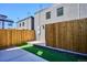 Modern backyard featuring artificial turf, a wood fence, and a concrete patio at 1825 Grove St, Denver, CO 80204